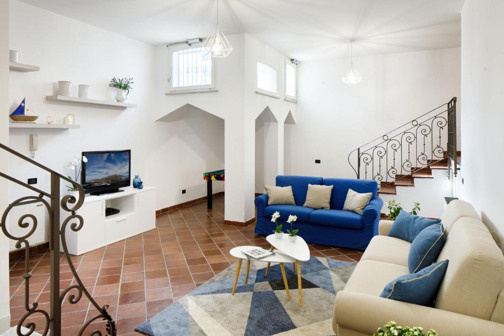 un salon avec des canapés bleus et une télévision dans l'établissement Villa D'Esposito - Sorrento Coast, à Sant'Agnello