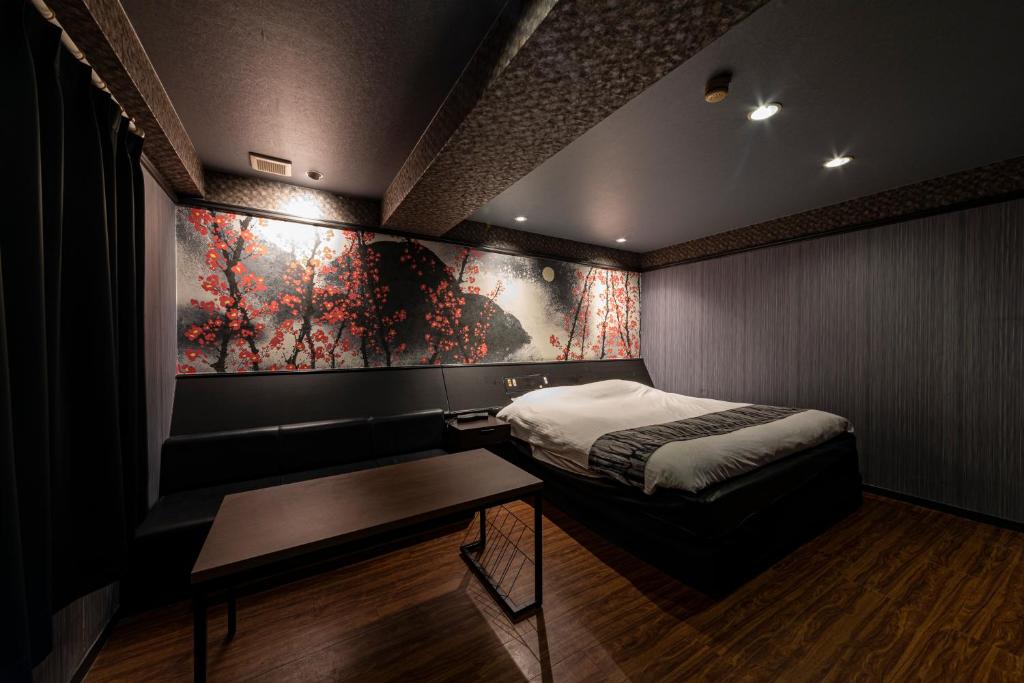une chambre avec un lit et un tableau au mur dans l'établissement HOTEL Mai Sakura, à Nara