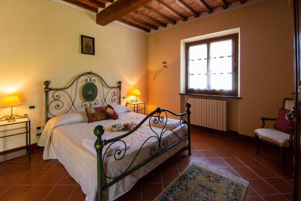 une chambre avec un lit et une fenêtre dans l'établissement Villa Degli Olivi, à Castiglion Fiorentino