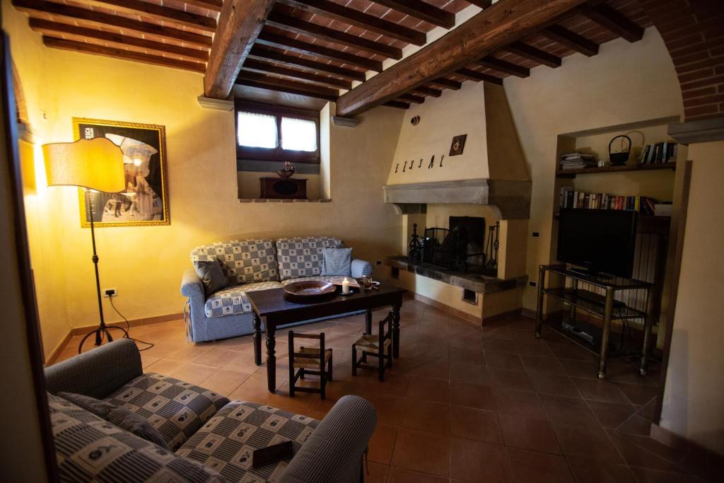 un salon avec un canapé et une table dans l'établissement Villa Degli Olivi, à Castiglion Fiorentino