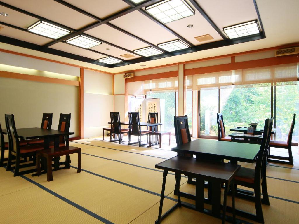 une salle à manger avec tables, chaises et fenêtres dans l'établissement Matsunoi, à Takayama 122 autres photos