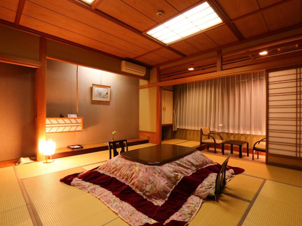 une pièce avec un lit et une table dedans dans l'établissement Matsunoi, à Takayama