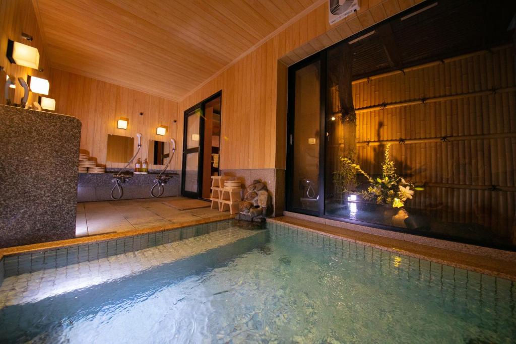 - une piscine dans une maison avec baignoire dans l'établissement Ohanabo, à Kyoto