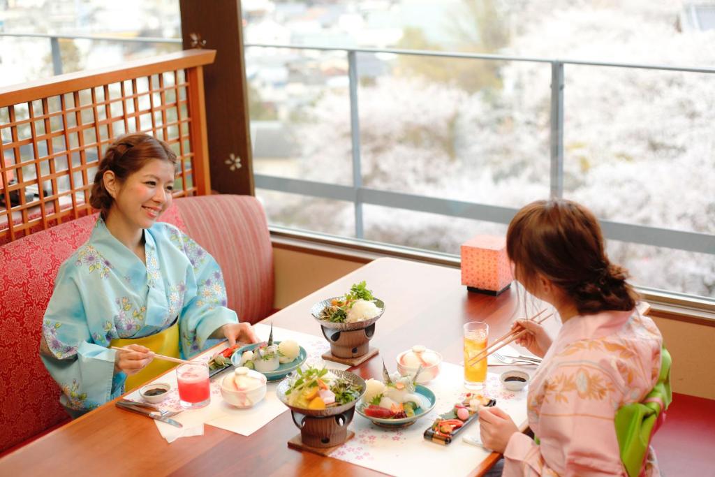 deux femmes assises à une table en train de manger dans l'établissement Kotohira Grand Hotel Sakuranosho, à Kotohira