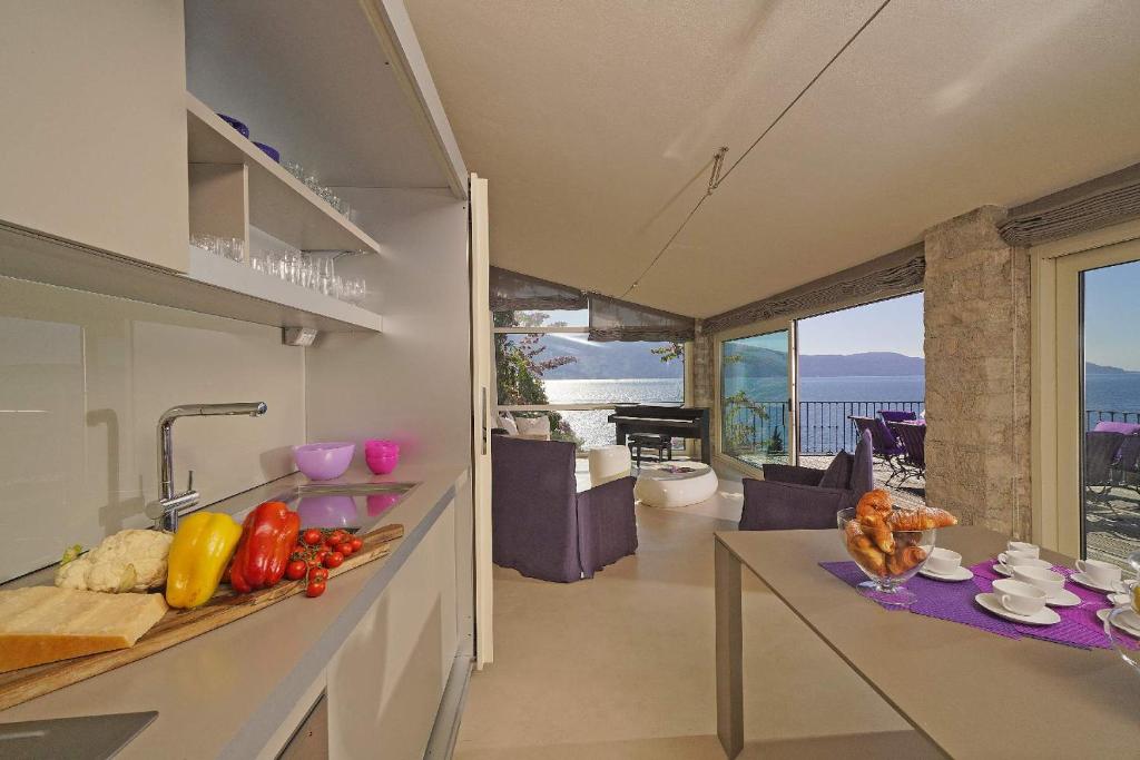 - une cuisine avec un comptoir avec des légumes dans l'établissement Villa Rachele: stunning luxury villa in centre Gargnano with private pool and breathtaking views, à Gargnano