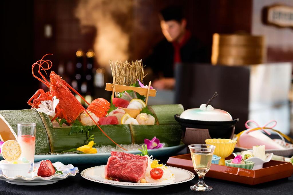 une table garnie d'assiettes de nourriture et de boissons dans l'établissement Kotohira Grand Hotel Sakuranosho, à Kotohira