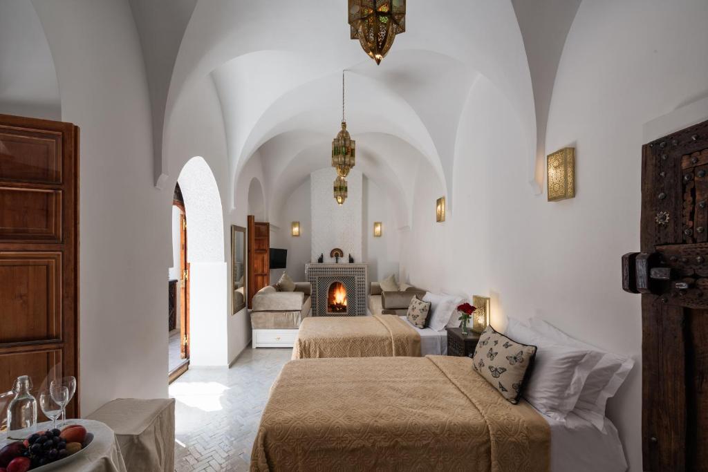 Cette chambre comprend 2 lits et une cheminée. dans l'établissement Riad Spice by Marrakech Riad, à Marrakech