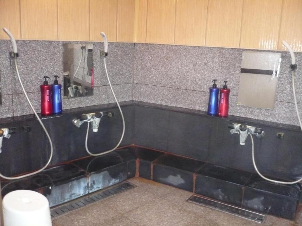 - une salle de bains avec 2 bouteilles d'eau sur le mur dans l'établissement Oyado Nozawaya, à Nozawa Onsen 35 autres photos