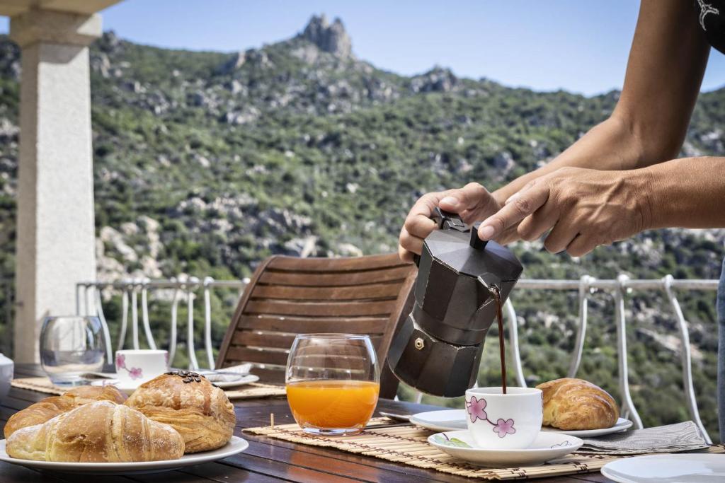 une personne verse du café sur une table avec de la nourriture dans l'établissement Porto Cervo-Villa La Gjanda, à Abbiadori 26 autres photos