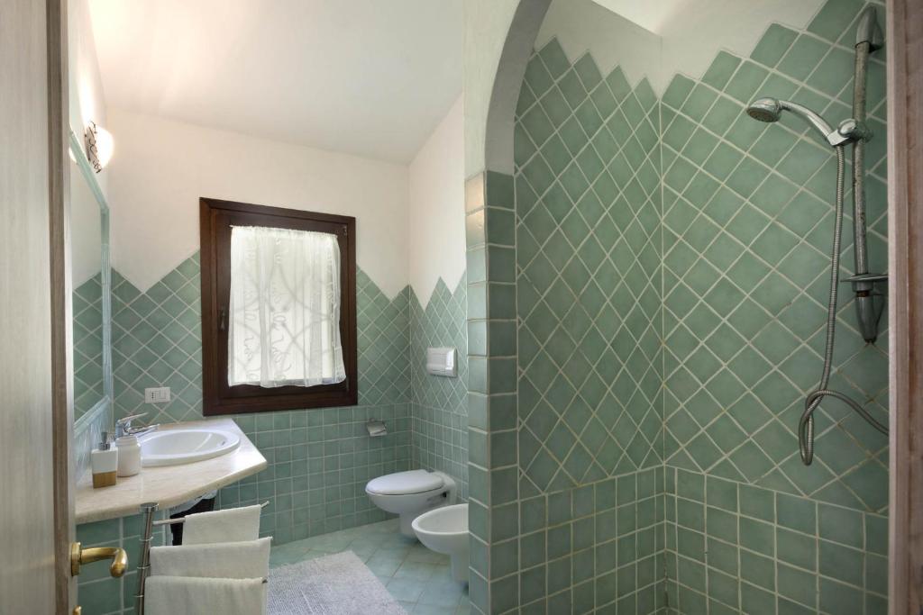 une salle de bain avec un lavabo, des toilettes et une douche dans l'établissement Porto Cervo-Villa La Gjanda, à Abbiadori