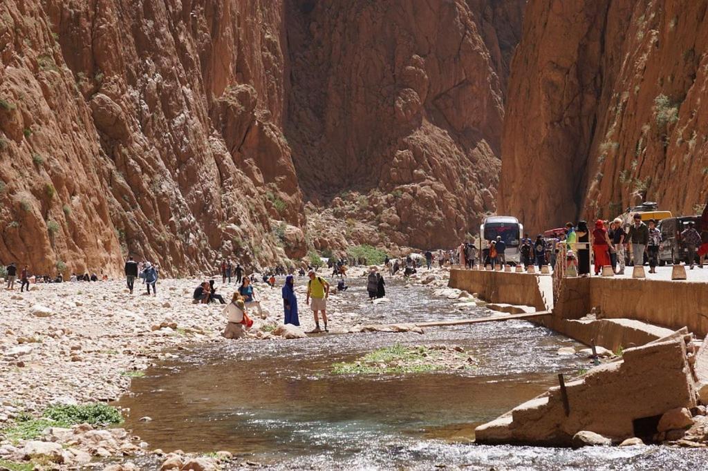 un groupe de personnes debout dans une rivière dans un canyon dans l'établissement Riad Amodou, à Tinghir