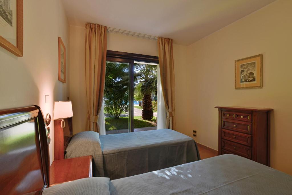 une chambre avec deux lits et une fenêtre dans l'établissement Minerva Resort Hotel, à Paestum