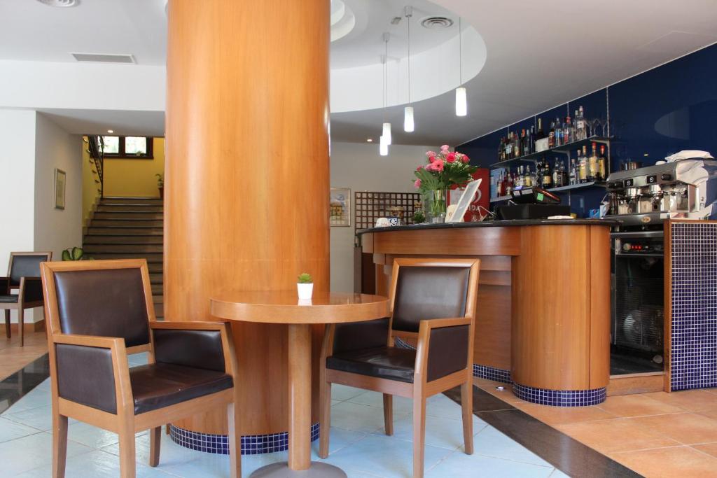 - un bar dans un restaurant avec deux chaises et une table dans l'établissement Parco Dei Principi, à Paestum