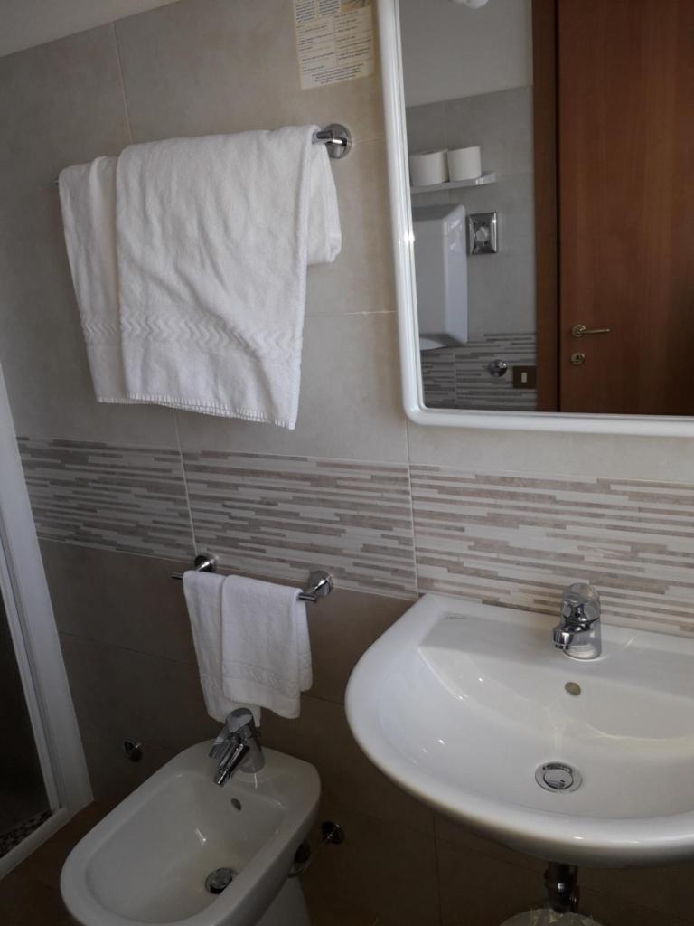 une salle de bain avec un lavabo, des toilettes et un miroir dans l'établissement Hotel Fornaci, à Peschiera del Garda