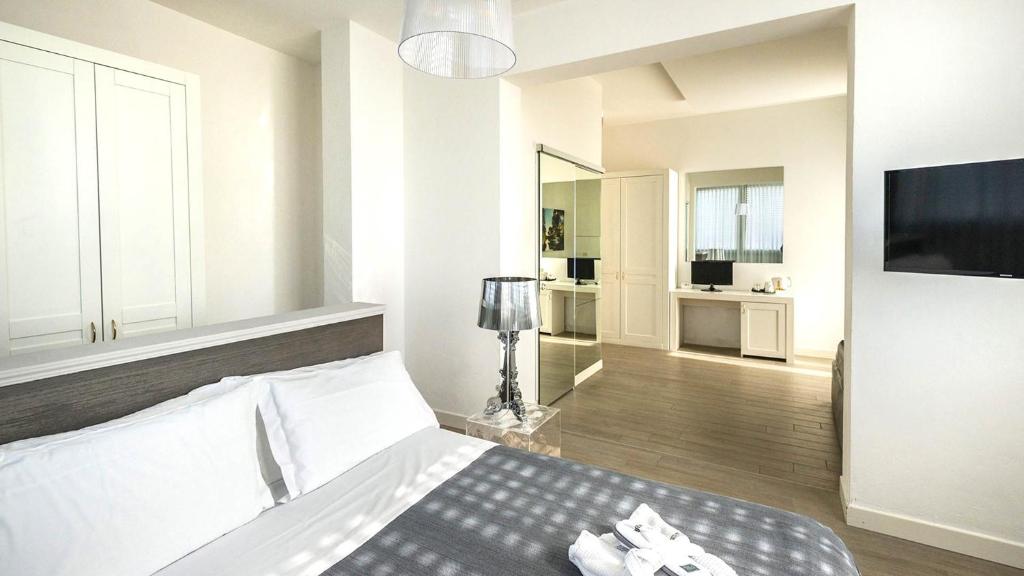 une chambre blanche avec un lit et une télévision dans l'établissement Perla Verde Hotel, à Milano Marittima