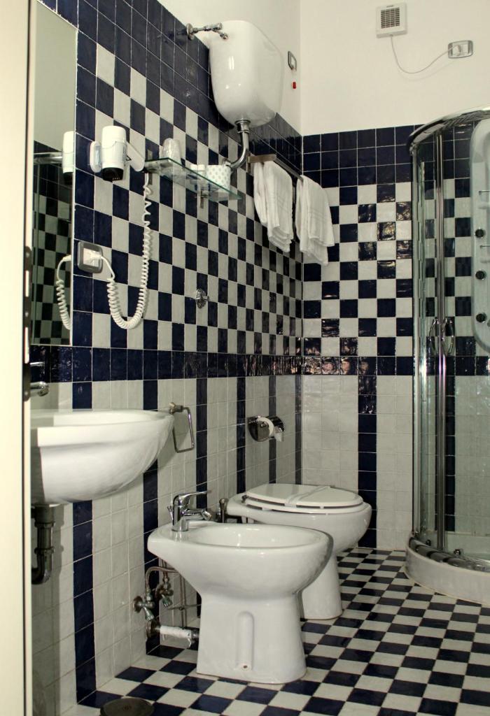 une salle de bain avec un lavabo, des toilettes et une douche dans l'établissement Parco Dei Principi, à Paestum