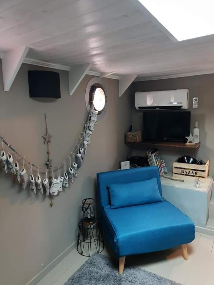 un salon avec une chaise bleue et un miroir dans l'établissement Le grand large, à Metz
