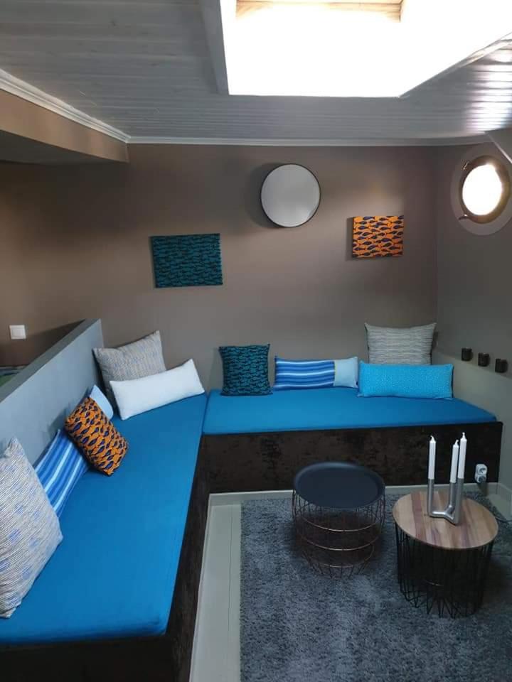 une chambre avec un canapé bleu et une table dans l'établissement Le grand large, à Metz