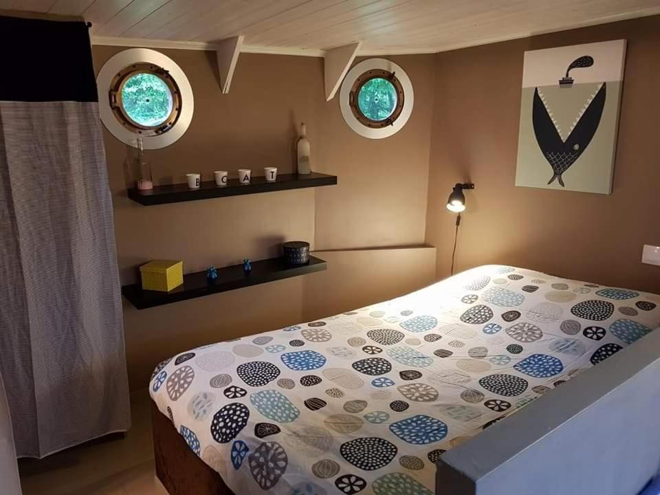 une chambre avec un lit et deux fenêtres dans l'établissement Le grand large, à Metz