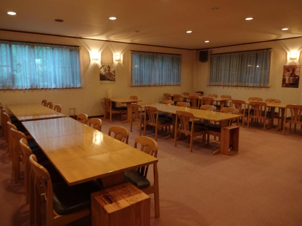 une salle à manger avec tables et chaises dans l'établissement Mizubasho no Yado Higashi, à Katashina 13 autres photos