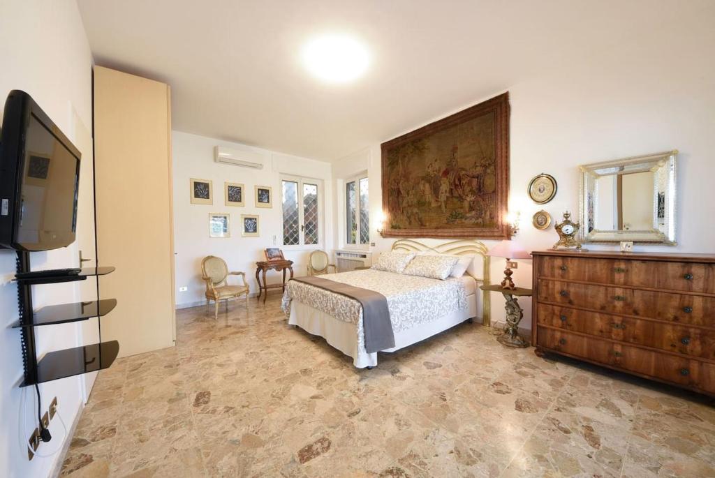 - une chambre avec un lit, une commode et une télévision dans l'établissement Villa Amalia Augusta, à Anguillara Sabazia