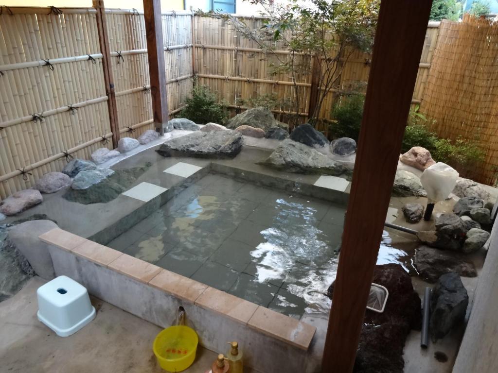 un bassin d'eau dans une cour avec des rochers dans l'établissement Hanasaku Onsen Yoshiyaso, à Katashina