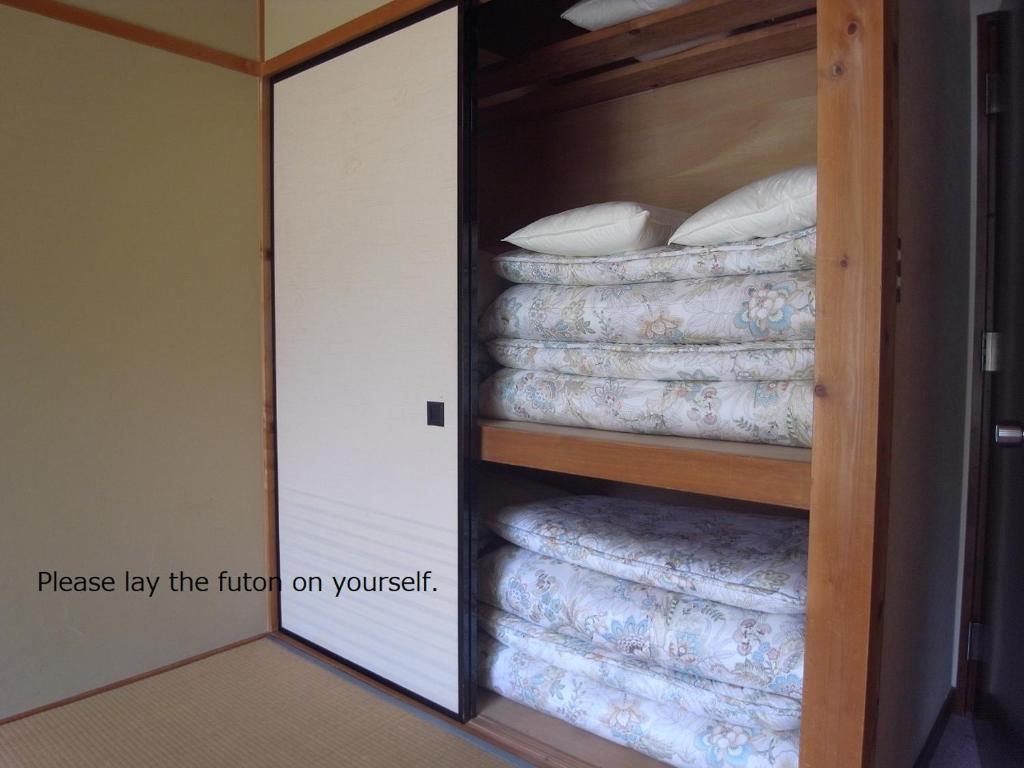 une chambre avec un placard rempli de matelas dans l'établissement Tokonamiso, à Nagiso