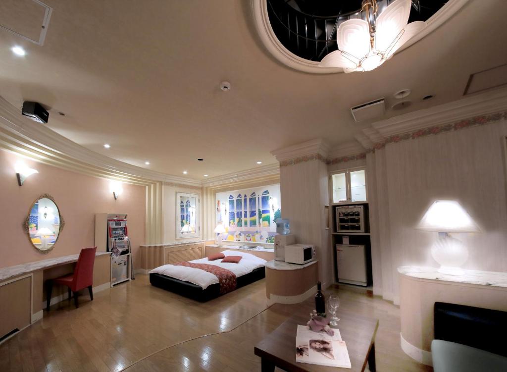 - une grande chambre avec un lit et une table dans l'établissement Hotel Mio City (Adult Only), à Yokkaichi