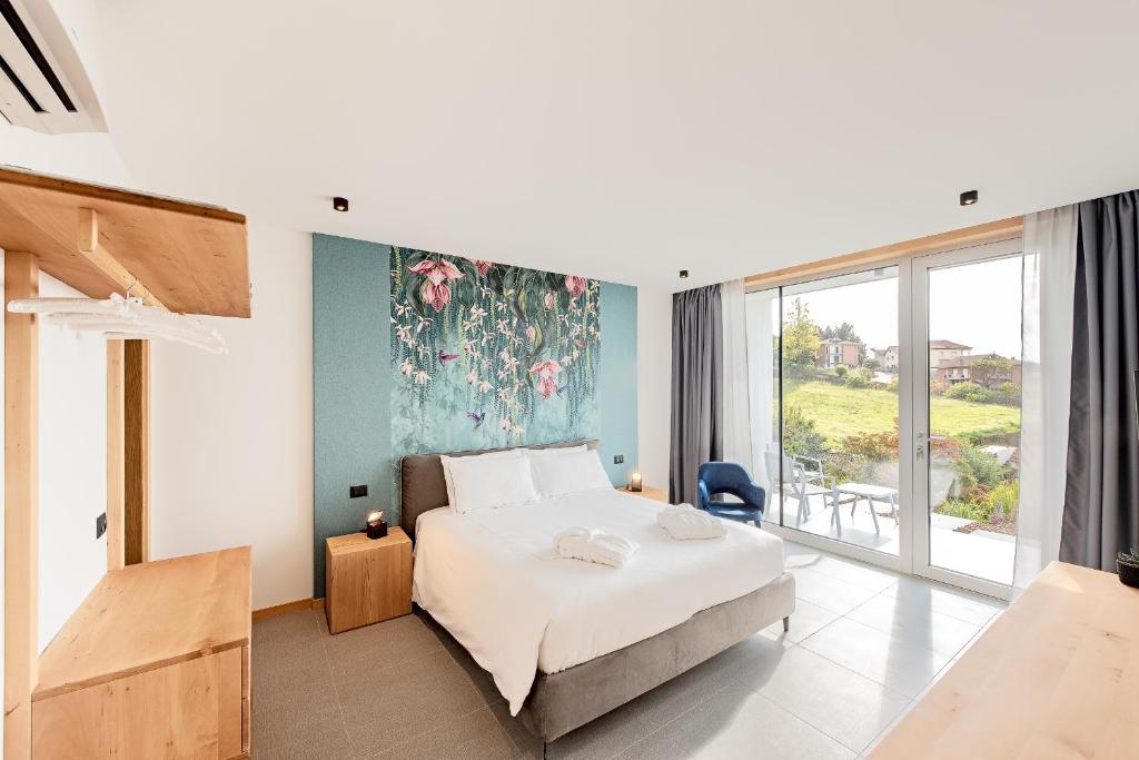 une chambre avec un lit et une grande fenêtre dans l'établissement Villa Anna, Luxury and private pool, à Alba