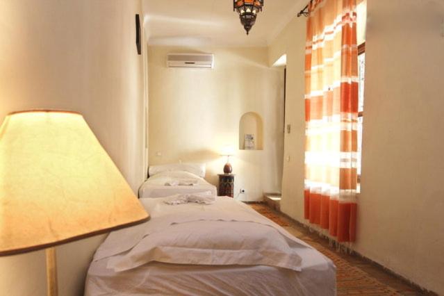 - une chambre avec 2 lits, une lampe et une fenêtre dans l'établissement Riad Al Faras, à Marrakech 37 autres photos