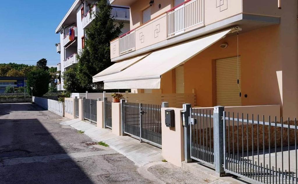 une clôture devant un bâtiment avec un auvent dans l'établissement Dépendance Lisa, à Pineto