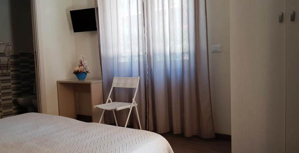 une chambre avec un lit et une chaise à côté d'une fenêtre dans l'établissement Dépendance Lisa, à Pineto