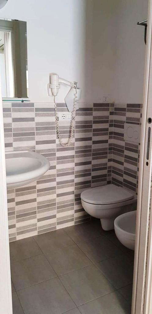 une salle de bain avec deux lavabos et un WC dans l'établissement Dépendance Lisa, à Pineto