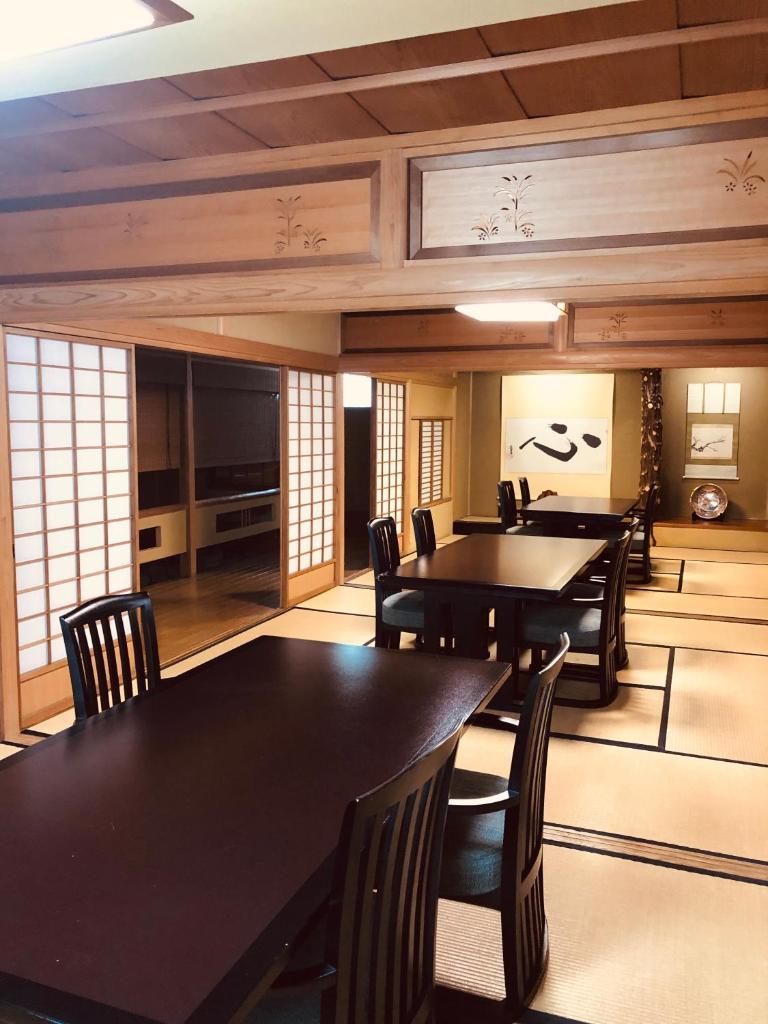 une salle à manger avec des tables et des chaises noires dans l'établissement Matsushima Koumura, à Matsushima