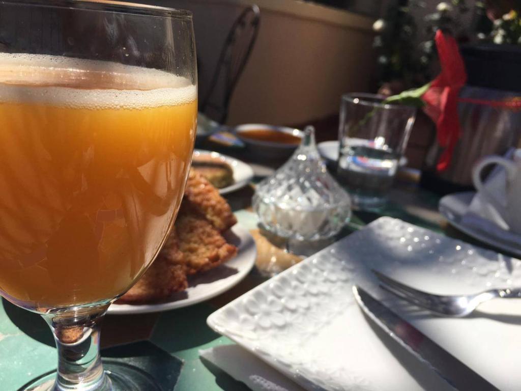 un verre de bière assis sur une table avec de la nourriture dans l'établissement Riad Fés blida, à Fès