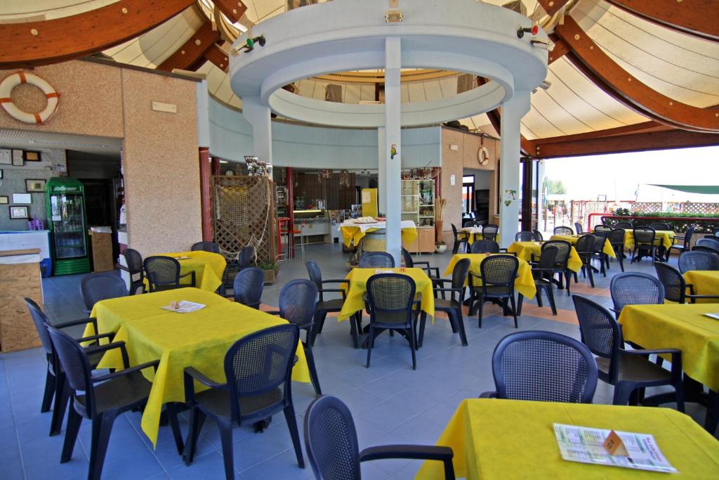 un restaurant vide avec des tables et des chaises jaunes dans l'établissement Hotel Cesare, à Giulianova