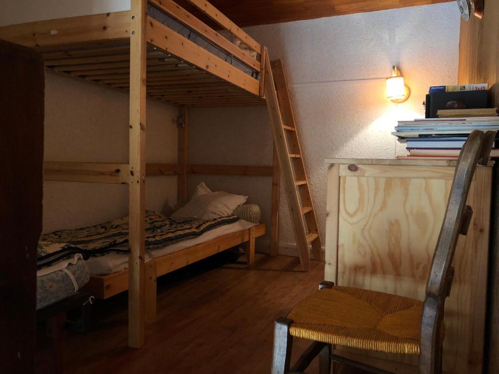 - une chambre avec 2 lits superposés et une chaise dans l'établissement Appartement Au Pied Des Pistes, à Puy-Saint-Vincent