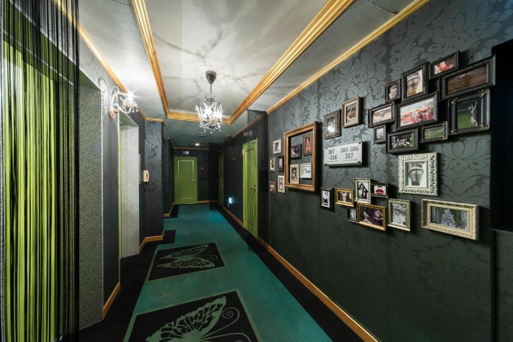 un couloir avec des murs verts et des photos sur les murs dans l'établissement Hotel Blanc Chapel Christmas Sakai (Adult Only), à Sakai