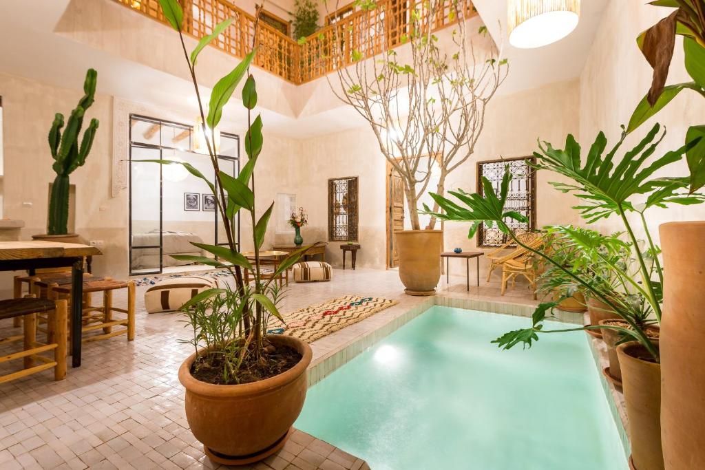 une grande piscine intérieure avec des plantes dans une pièce dans l'établissement Medina Sun, à Marrakech