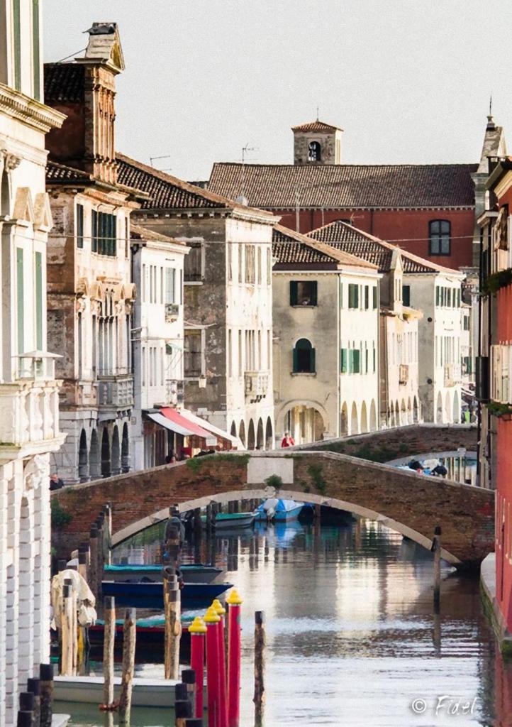 un pont sur un canal dans une ville avec des bâtiments dans l'établissement Residence Eleonora, à Sottomarina
