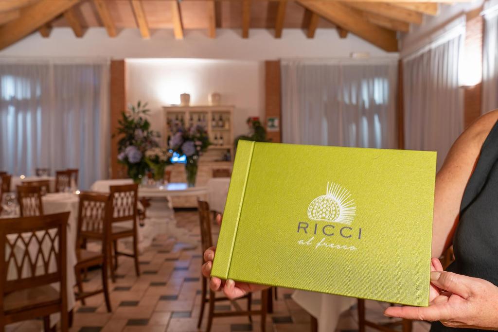 une personne détenant une carte verte dans un restaurant dans l'établissement Ricci Hotel - Marina di Grosseto, à Marina di Grosseto
