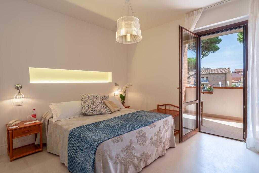 une chambre avec un lit et un balcon dans l'établissement Ricci Hotel - Marina di Grosseto, à Marina di Grosseto