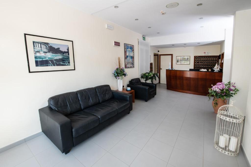 - un salon avec un canapé en cuir noir et un hall dans l'établissement Hotel Torretta, à Cattolica