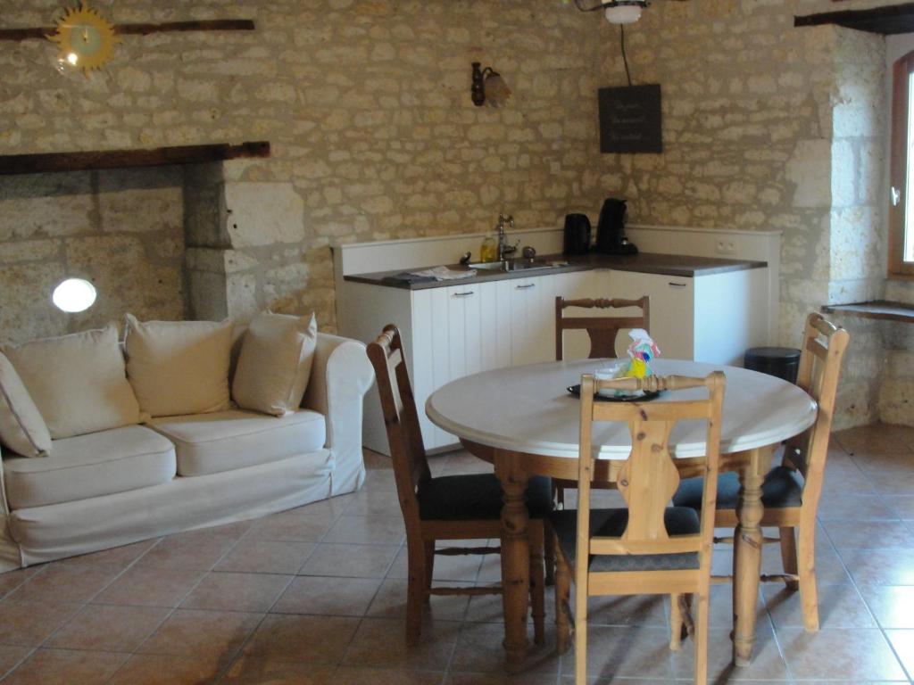 un salon avec une table et un canapé blanc dans l'établissement Gites La Peyroulière, à Aurignac