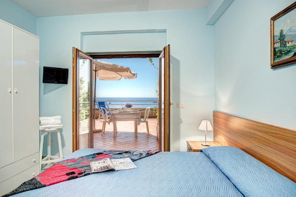 une chambre avec un lit et une vue sur l'océan dans l'établissement Belmare Residence on the beach, à Nerano