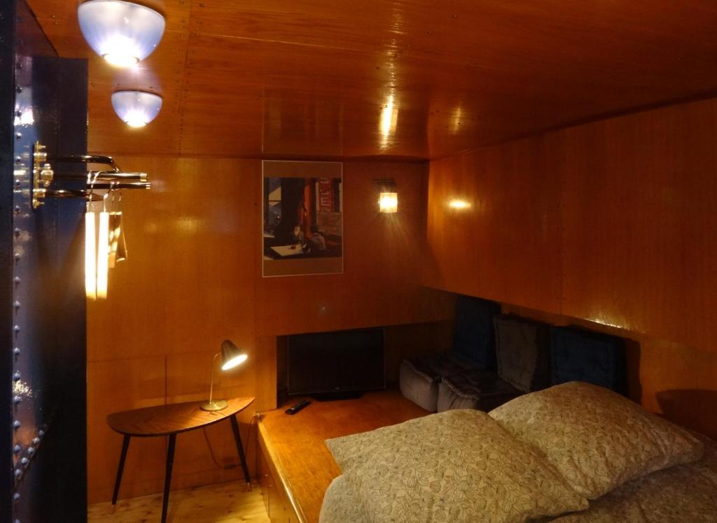 une chambre avec un lit et une cheminée dans l'établissement Bateau, Péniche Marboré - Disney, à Lagny-sur-Marne