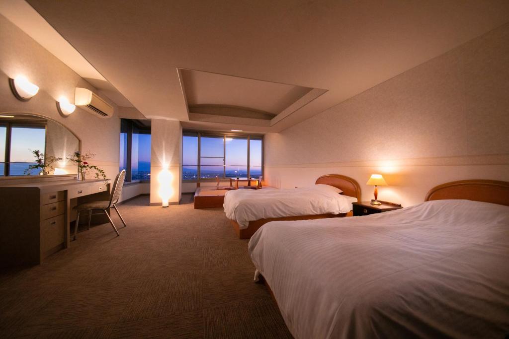 une chambre d'hôtel avec deux lits et un bureau dans l'établissement Omuta Heights, à Ōmuta