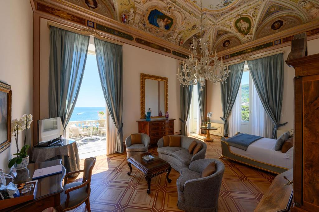 un salon avec un lustre et une chambre avec un canapé et des chaises dans l'établissement Imperiale Palace Hotel, à Santa Margherita Ligure