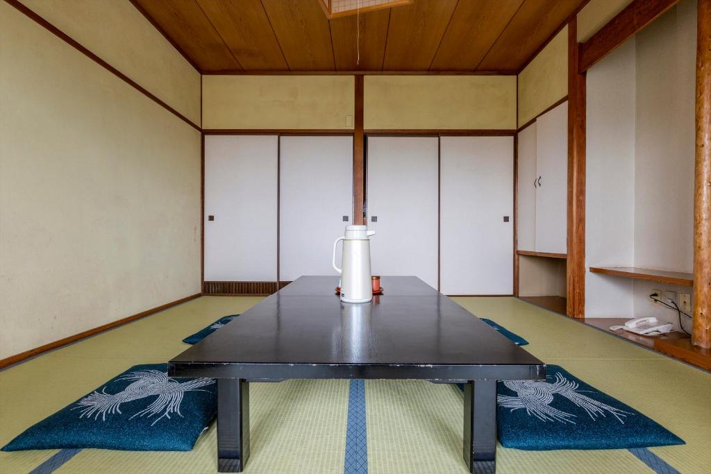 une pièce vide avec une table au milieu dans l'établissement Tsuruga Tunnel Onsen Kitaguni Grand Hotel, à Tsuruga