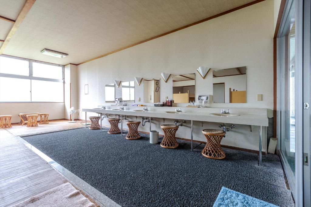 une grande chambre avec une grande grande table et des lavabos dans l'établissement Tsuruga Tunnel Onsen Kitaguni Grand Hotel, à Tsuruga